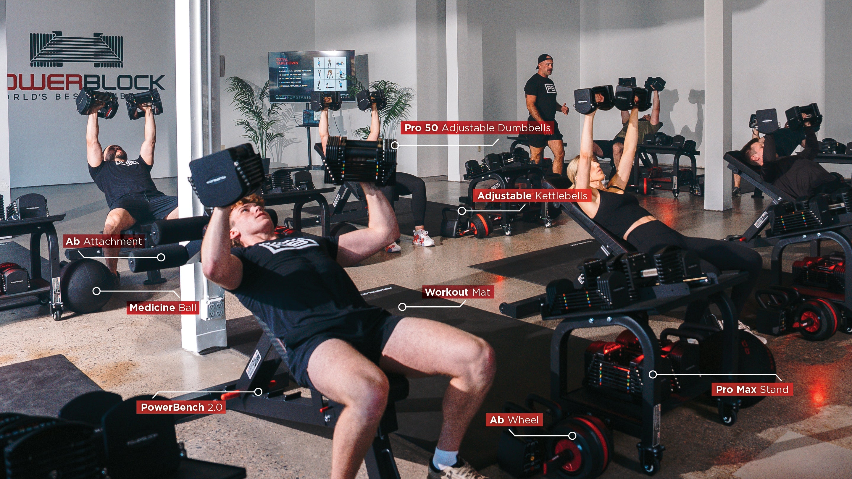 A product shot during a powerblock fitness studio class, members are doing dumbbell incline bench presses. We can see powerblock adjustable dumbbells, kettlebells, ab wheels, med balls, benches, and more.